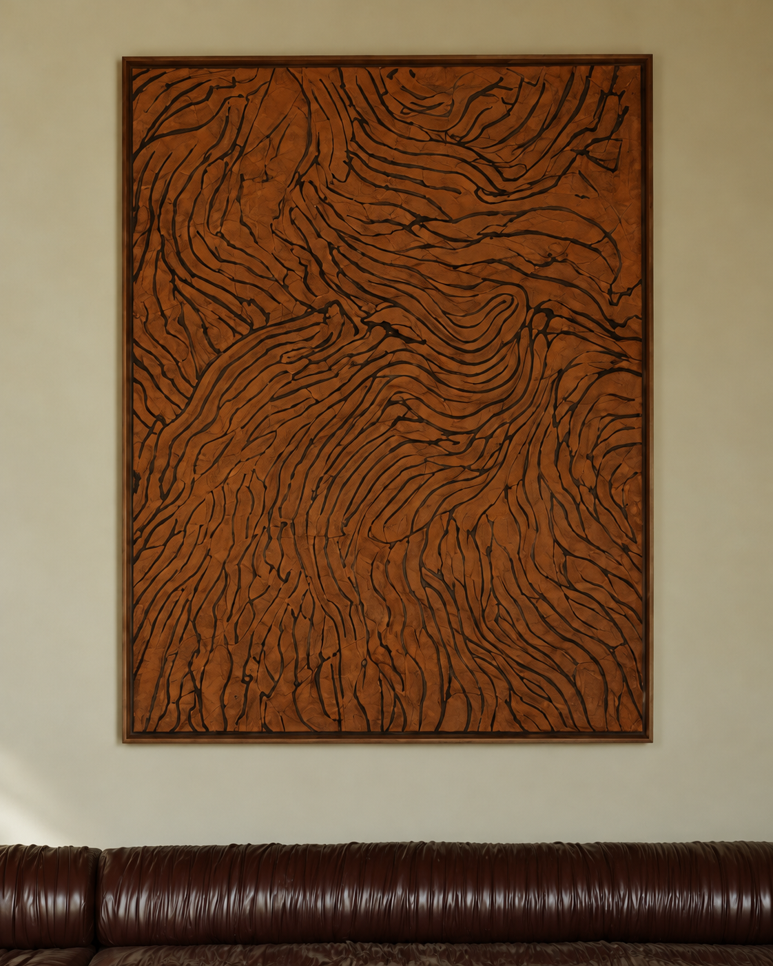 Terracotta Veins, a large textured abstract painting with flowing black lines on a warm rust-brown surface, framed in dark wood above a brown leather sofa.